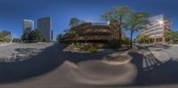 fisheye lens on a skate park, with multiple buildings in the background in the day time