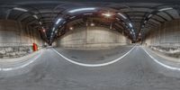 a fish - eye view of a skate park in the middle of a tunnel with ramps and a ramp and concrete walls