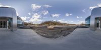 the skateboarder is riding through the concrete half pipe at the skate park under a cloudy blue sky