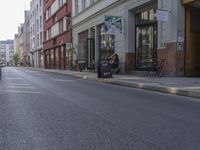 a person riding a skateboard down the middle of a street with buildings on both sides of it