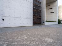 a skateboard in the cement next to a building and another skate board in the middle