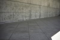 a skateboard in a concrete building and its shadow on the ground to show it