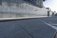 a man riding a skateboard in the middle of a concrete wall next to a road