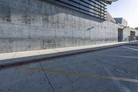 a man riding a skateboard in the middle of a concrete wall next to a road