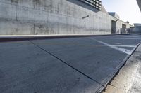 a man riding a skateboard in the middle of a concrete wall next to a road