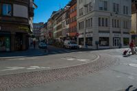 a person riding a skateboard across a bricked crosswalk in a town street