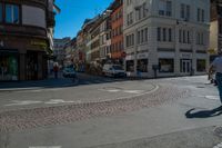 a person riding a skateboard across a bricked crosswalk in a town street