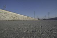 a skateboard on the ground in front of an overpassed dam near a bridge