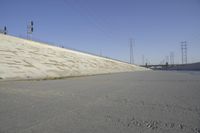 a skateboard on the ground in front of an overpassed dam near a bridge