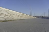 a skateboard on the ground in front of an overpassed dam near a bridge