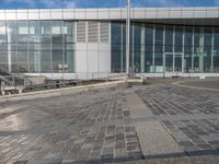 the skateboard is in front of a building and a walkway beside it that appears to have been set up into concrete