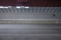 a person riding a skateboard on the top of a ramp in a parking garage