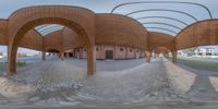 a fish eye image of a skateboard park with many walls and arches inside a brick building