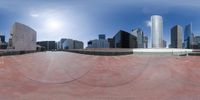 a large skateboard park with the city skyline in the background, and buildings on the other side