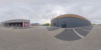 a fish - eye lens view of a skateboard park at the edge of a shopping mall