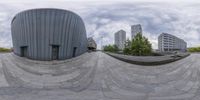 the person is practicing his moves in the skateboard park outside a building area with buildings behind them