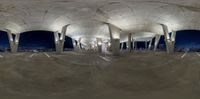 an empty skateboard park with many ramps and lots of traffic lights, taken from a fisheye lens