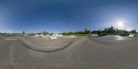 a view of the sky from a fisheye lens of skateboard park with ramps