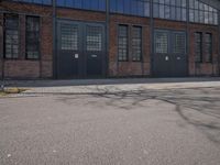 a skateboard is parked on the pavement in front of a building with large windows