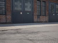 a skateboard is parked on the pavement in front of a building with large windows