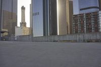 a skateboard is parked on the concrete in front of some tall buildings and some skyscrapers