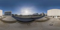 a 360 - turn view of the underside of a skateboard ramp with buildings in the background