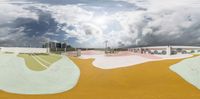 the skateboard ramp is painted in many colors as well as clouds above it that appear to be made from different layers