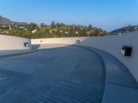 a skate board ramp sits on the side of a roof over a city and mountain