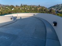 a skate board ramp sits on the side of a roof over a city and mountain