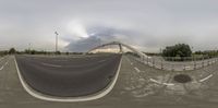 skateboard ramp with people on top as viewed from the underside end of it and a metal pole