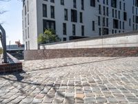 a person riding a skate board with a building in the background on a brick walkway