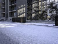 a skateboard that is sitting on top of the snow covered ground near a building