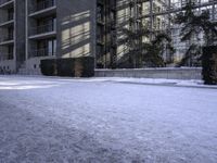 a skateboard that is sitting on top of the snow covered ground near a building