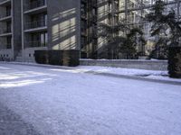 a skateboard that is sitting on top of the snow covered ground near a building