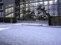 a skateboard that is sitting on top of the snow covered ground near a building