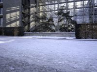 a skateboard that is sitting on top of the snow covered ground near a building