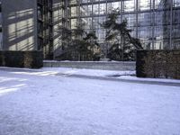 a skateboard that is sitting on top of the snow covered ground near a building