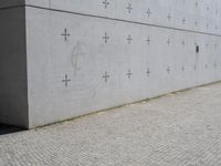 an individual doing a skateboard trick while other person looks on from the sidewalk in front of them