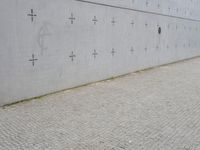 an individual doing a skateboard trick while other person looks on from the sidewalk in front of them