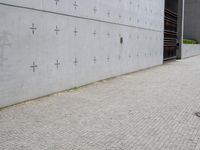 an individual doing a skateboard trick while other person looks on from the sidewalk in front of them