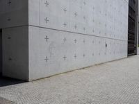 an individual doing a skateboard trick while other person looks on from the sidewalk in front of them