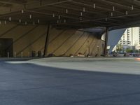 a man doing tricks on a red skateboard in an empty parking garage and city skyline