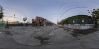 a fish eye picture taken of a skateboarder performing an air trick in the street