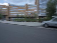 a blurry photo of a man skateboarding on a city street with buildings in the background