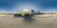 a 360 lens image of skateboarder doing a trick in front of a building