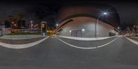 an image of a skate boarder on a ramp near some buildings at night time