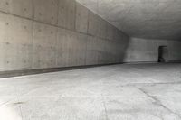 a skateboarder skating down a concrete alley way and its reflection on the wall