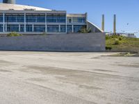 a skateboarder going around on a concrete course in front of a large building