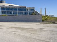 a skateboarder going around on a concrete course in front of a large building