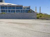 a skateboarder going around on a concrete course in front of a large building